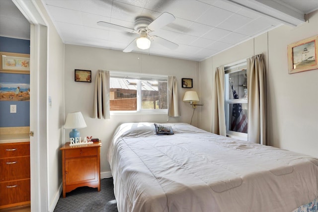 bedroom with dark carpet, ceiling fan, and baseboards