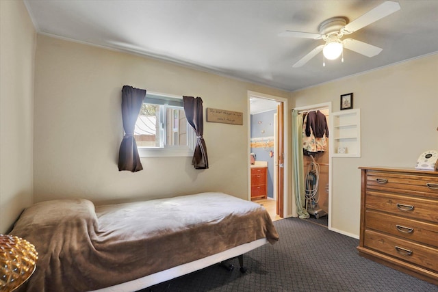 bedroom with crown molding, a ceiling fan, dark carpet, and connected bathroom
