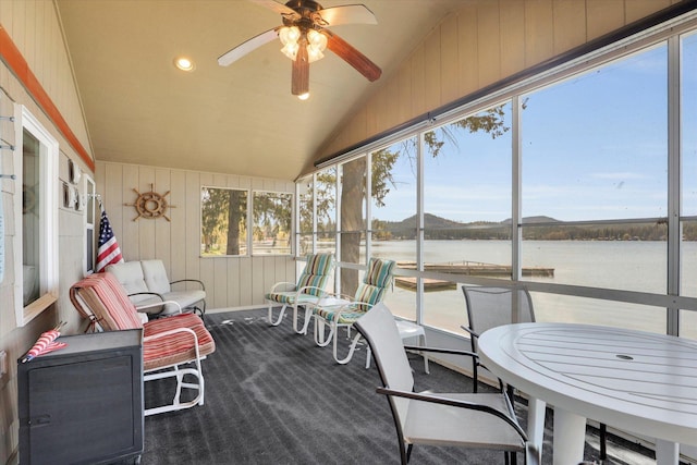 sunroom featuring a ceiling fan and a water view
