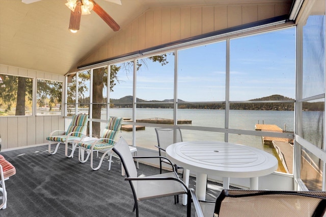 sunroom with a ceiling fan, a wealth of natural light, a water view, and lofted ceiling