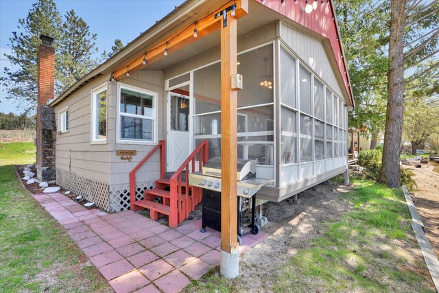 exterior space featuring a chimney and a sunroom