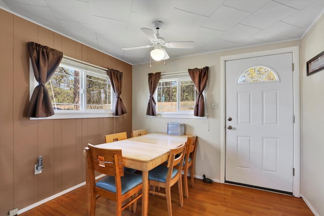 dining room with ornamental molding, ceiling fan, wood finished floors, and baseboards