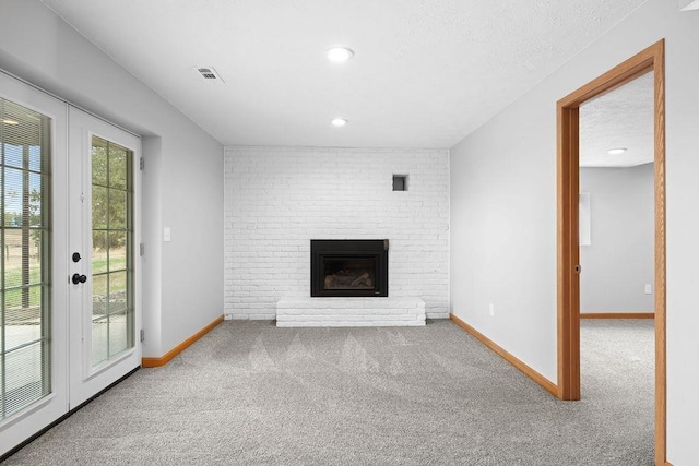12115 E Wedgewood Ct, Spokane, WA 99217 - unfurnished living room featuring carpet flooring, french doors, baseboards, a brick fireplace, and a textured ceiling