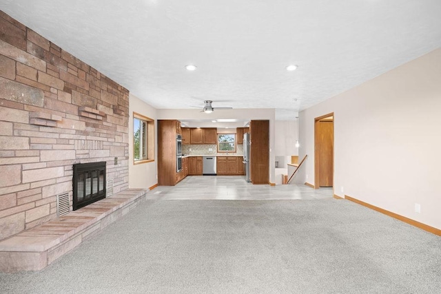12115 E Wedgewood Ct, Spokane, WA 99217 - unfurnished living room with baseboards, a stone fireplace, ceiling fan, light colored carpet, and recessed lighting
