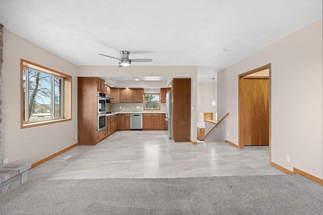 12115 E Wedgewood Ct, Spokane, WA 99217 - kitchen featuring stainless steel appliances, brown cabinets, light countertops, and healthy amount of natural light