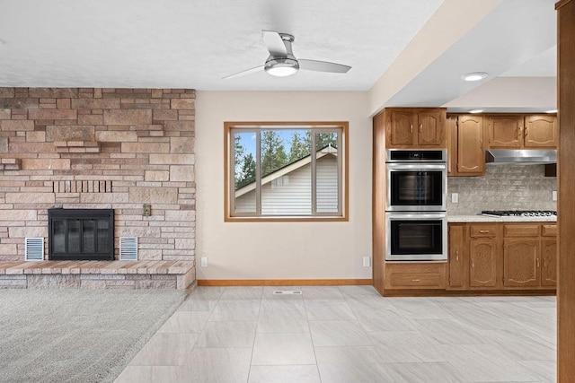 12115 E Wedgewood Ct, Spokane, WA 99217 - kitchen featuring stainless steel double oven, under cabinet range hood, baseboards, tasteful backsplash, and ceiling fan