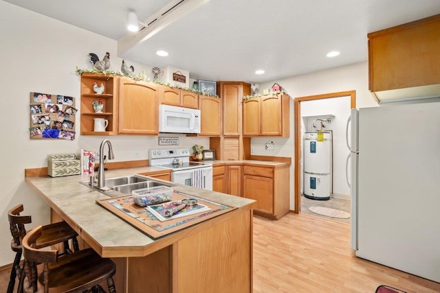 146 Laurelhurst Dr Unit 146, Newport, WA 99156 - kitchen featuring a peninsula, a sink, a kitchen breakfast bar, white appliances, and secured water heater
