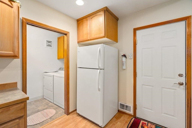 146 Laurelhurst Dr Unit 146, Newport, WA 99156 - washroom featuring light wood-type flooring, washer and dryer, visible vents, and cabinet space