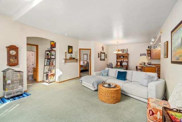 146 Laurelhurst Dr Unit 146, Newport, WA 99156 - carpeted living room with baseboards, arched walkways, and a notable chandelier