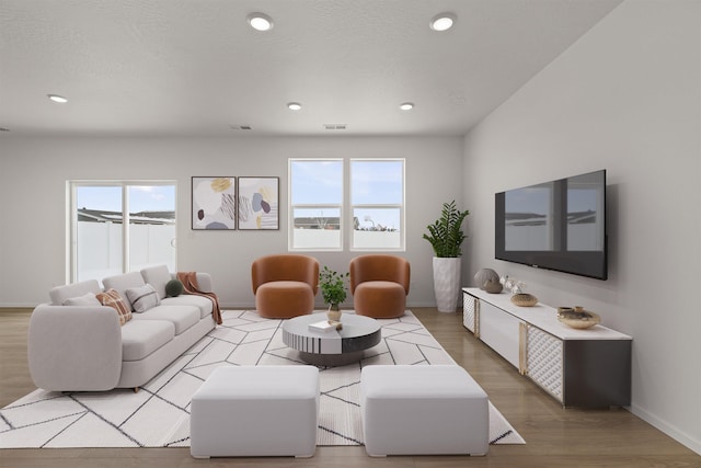 living room featuring a textured ceiling, visible vents, light wood-style flooring, baseboards, and recessed lighting