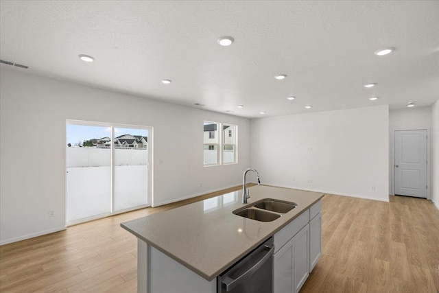kitchen featuring light wood-type flooring, a sink, visible vents, and stainless steel dishwasher