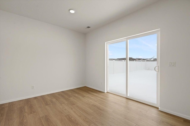 unfurnished room with baseboards, visible vents, and light wood-style flooring