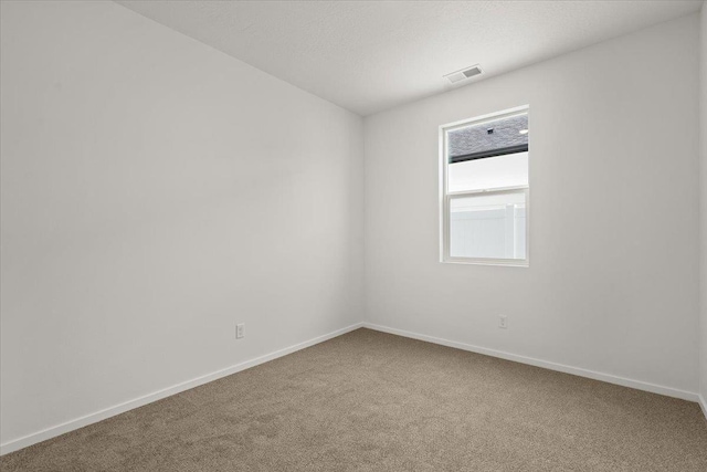 unfurnished room featuring baseboards, carpet flooring, and visible vents