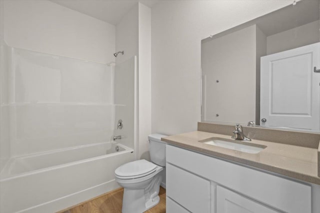 bathroom featuring toilet, vanity, shower / washtub combination, and wood finished floors