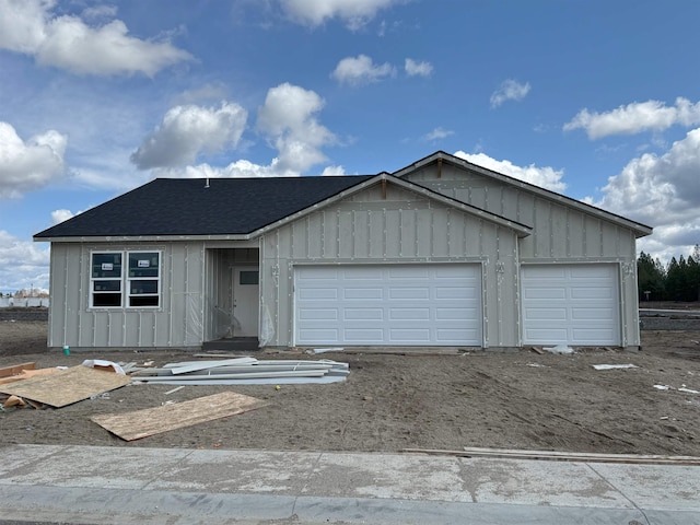 ranch-style house featuring board and batten siding, roof with shingles, and an attached garage