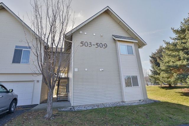 exterior space with a front yard, a garage, and stairway