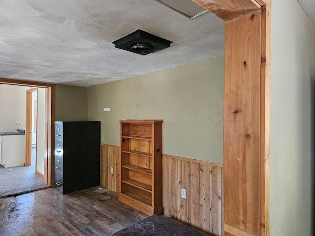 3610 Sand Creek Rd, Kettle Falls, WA 99141 - interior space featuring wooden walls, wood finished floors, a sink, wainscoting, and a textured ceiling