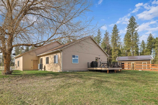 rear view of house with fence, a yard, and a wooden deck