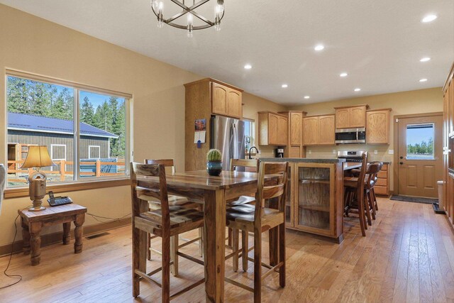 dining room featuring visible vents, a notable chandelier, light wood-style floors, and a wealth of natural light