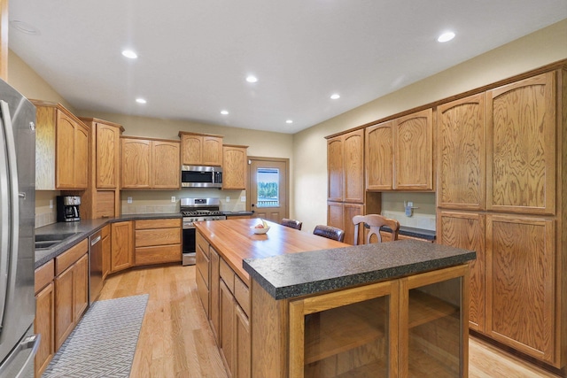 kitchen featuring recessed lighting, stainless steel appliances, a center island, and light wood-type flooring