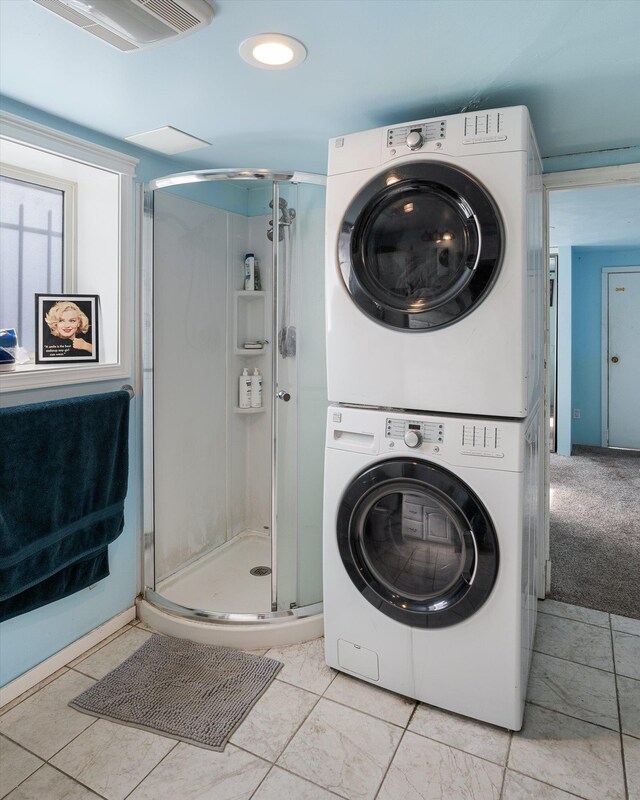 laundry area featuring carpet flooring, stacked washer and clothes dryer, laundry area, and visible vents