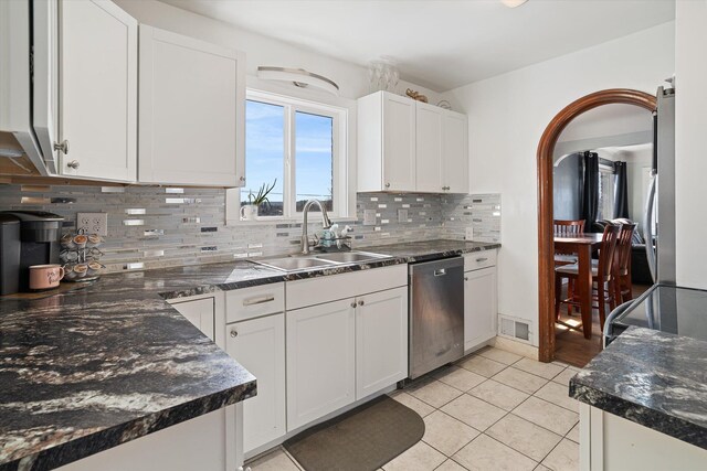 kitchen with a sink, dark countertops, visible vents, and stainless steel dishwasher
