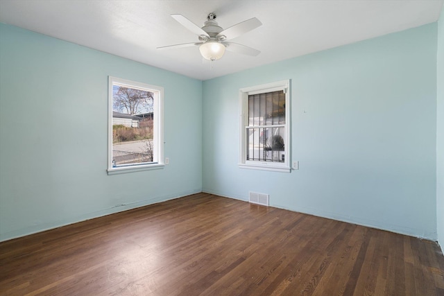 unfurnished room featuring wood finished floors, ceiling fan, and visible vents