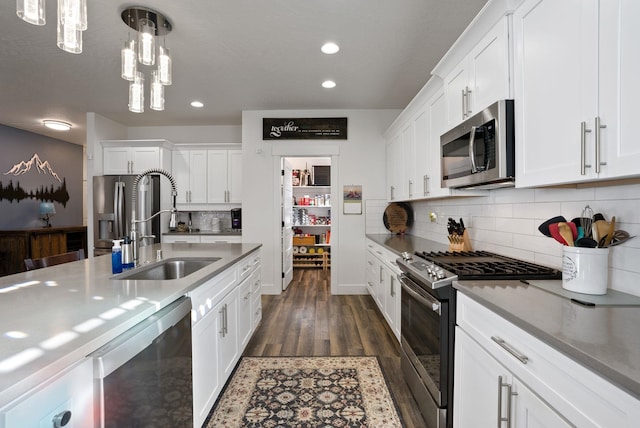 kitchen with white cabinets, dark wood-style flooring, a sink, and stainless steel appliances