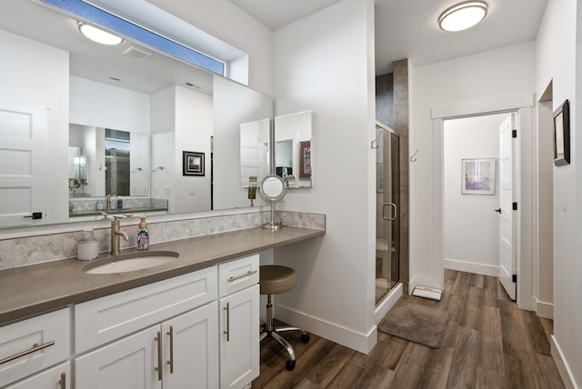 full bathroom featuring visible vents, a shower stall, baseboards, wood finished floors, and vanity
