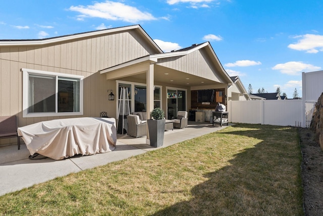 back of house with a lawn, fence, an outdoor living space, and a patio