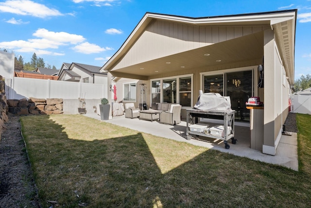 back of property with outdoor lounge area, fence, a patio, and a yard