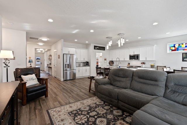 living room with an inviting chandelier, dark wood-style flooring, recessed lighting, and visible vents