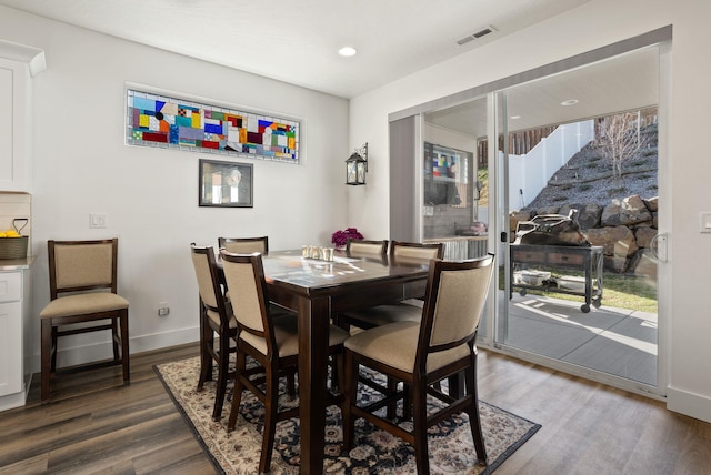dining area featuring wood finished floors, a healthy amount of sunlight, baseboards, and visible vents