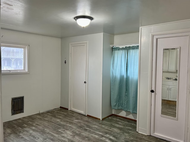 unfurnished bedroom featuring dark wood-style floors and visible vents
