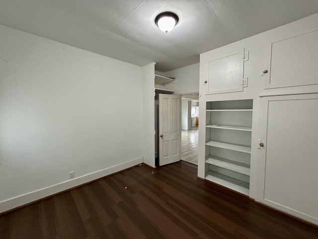 unfurnished bedroom with dark wood-style floors and baseboards