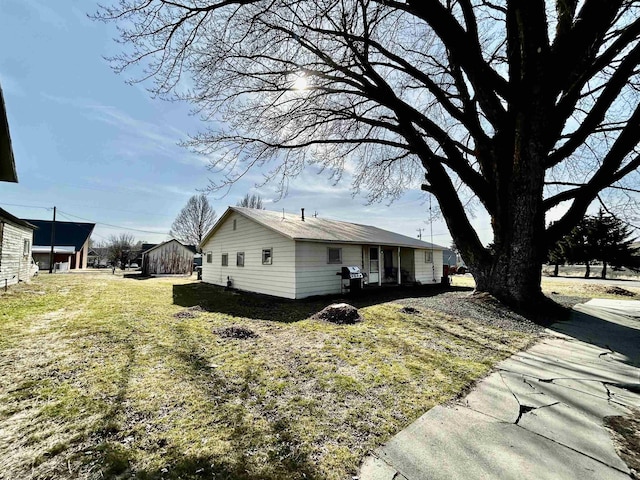 view of side of home with a yard