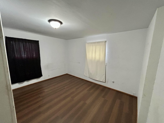 unfurnished room with baseboards and wood finished floors