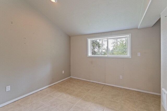 4720 S Wildwood Ln, Spokane, WA 99206 - unfurnished room with baseboards, a textured ceiling, visible vents, and vaulted ceiling