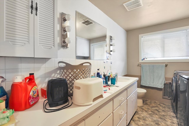 908 E Rockwell Avenue 910E Rockwell Ave, Spokane, WA 99207 - bathroom featuring separate washer and dryer, visible vents, toilet, and tasteful backsplash