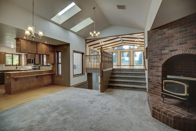5910 N Thierman Rd, Spokane, WA 99217 - unfurnished living room with a chandelier, lofted ceiling, a skylight, light carpet, and a sink
