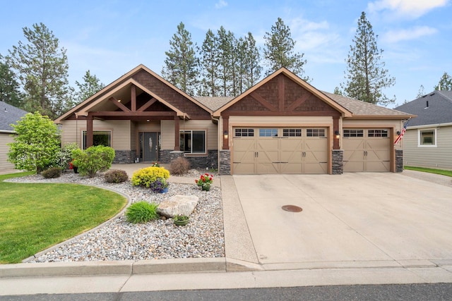 craftsman house with a front yard, concrete driveway, stone siding, and a garage