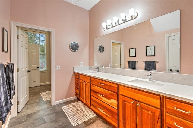 6808 S Jackson Ridge Ln, Greenacres, WA 99016 - bathroom with double vanity, wood finished floors, baseboards, and a sink