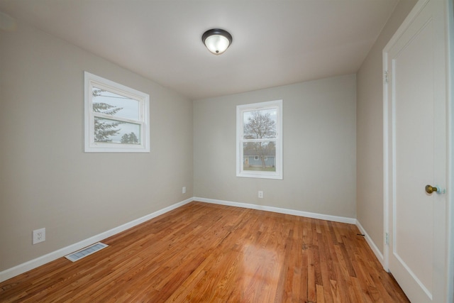 unfurnished room featuring visible vents, baseboards, and light wood-style floors