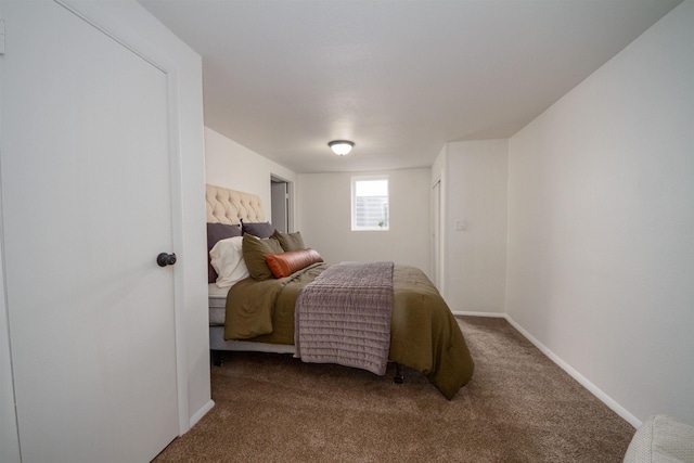 bedroom with baseboards and dark carpet