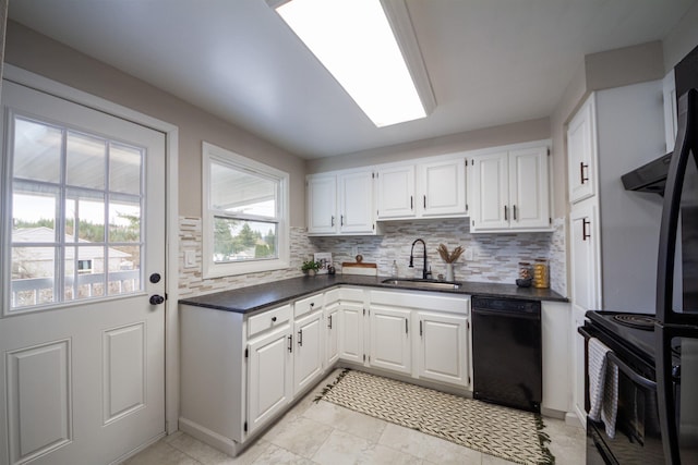 kitchen with a sink, black appliances, backsplash, dark countertops, and white cabinets