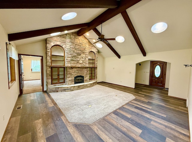 unfurnished living room with dark wood-style flooring, visible vents, beamed ceiling, a fireplace, and ceiling fan