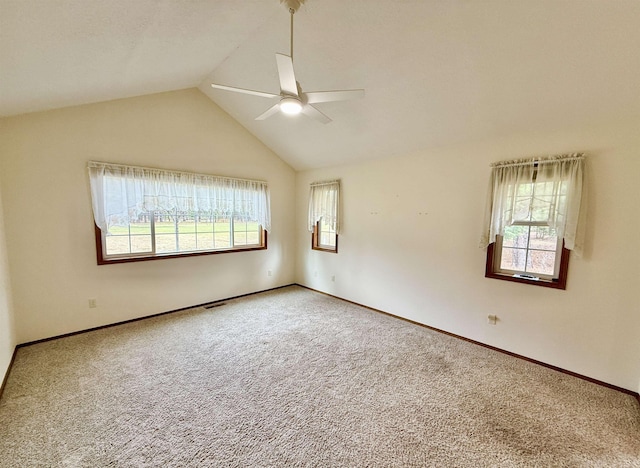 carpeted spare room with baseboards, lofted ceiling, visible vents, and a ceiling fan