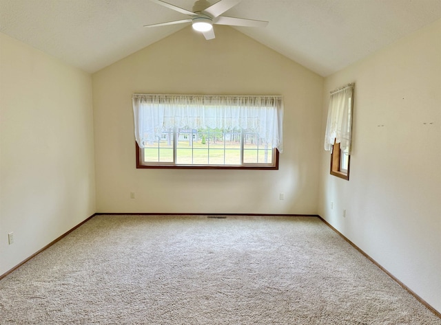 unfurnished room with vaulted ceiling, carpet, baseboards, visible vents, and ceiling fan