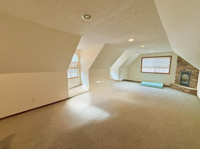 bonus room featuring baseboards, vaulted ceiling, carpet, and a textured ceiling