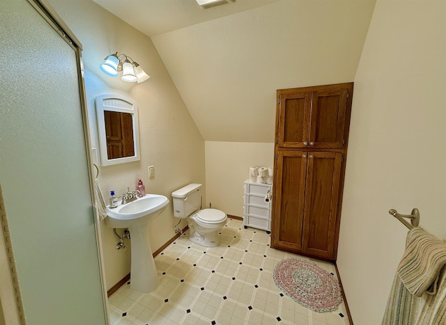 bathroom featuring tile patterned floors, vaulted ceiling, toilet, a sink, and baseboards
